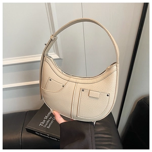 Detail of off-white lychee texture leather crescent bag with double front pocket and studs