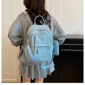 Litchi texture faux leather light blue backpack showing stitching and zipper details on model
