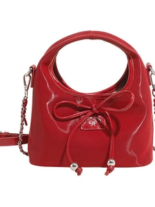 Sac bandoulière rouge en cuir verni brillant avec bandoulière chaîne et nœud