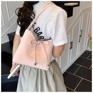 Détail du sac à bandoulière rose clair avec nœud coulissant et perles métalliques