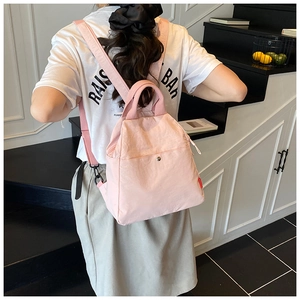Detail of pink waterproof nylon backpack showing reinforced top handle and buckle