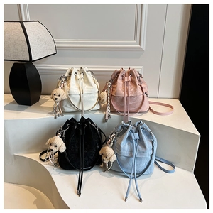 Close-up of drawstring bucket bags in four colors with cute plush dog charm accessories