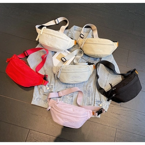Detailed flat lay of canvas waist bags in six colors with adjustable nylon straps