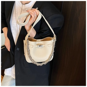 Dettaglio della borsa a secchiello in pelle martellata con chiusura a scatto e catena argento