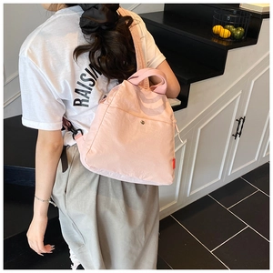Pink versatile chest bag with lightweight nylon texture and front pocket view