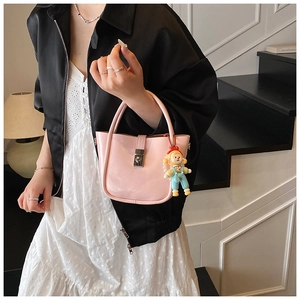 Pink glossy leather bucket bag featuring silver twist lock and cute cartoon charm