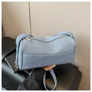 Close-up of light blue denim Boston bag showing fabric texture and silver metal zipper