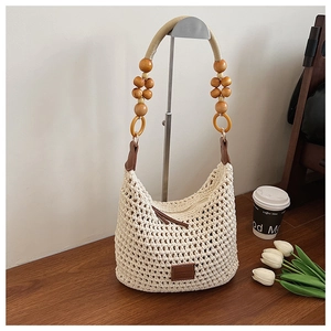 Détail d'un sac seau en maille avec perles en bois et écusson en cuir élégant