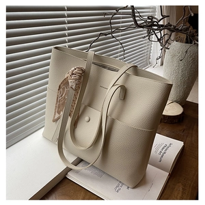 Detail of cream leather tote bag with printed silk scarf on handle and front pocket