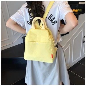 Detailed view of lightweight bright yellow backpack with reinforced top handle and side pocket