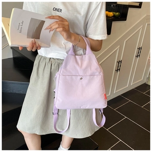 Detail view of light purple nylon chest bag showing magnetic front pocket and top handle