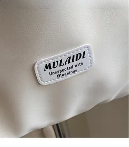 Macro shot of faux leather texture with stitched logo label on minimalist tote bag
