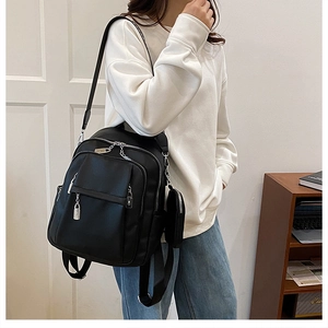 Detail of black pebbled PU leather backpack featuring silver hardware and side pockets