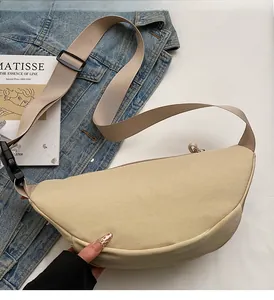 Detail of beige crescent canvas crossbody bag with adjustable strap and casual buckle