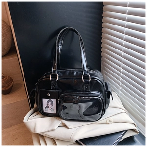 Detail of black glossy handbag with functional front pockets and transparent card slots