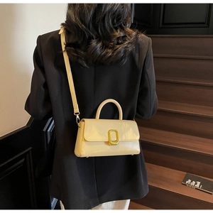 Vue arrière d'un mannequin portant un sac à main crème brillant sur un escalier