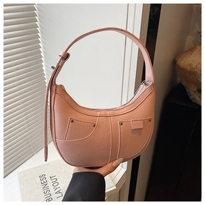 Detail of pink hobo bag featuring lychee texture, rivets, and decorative stitching