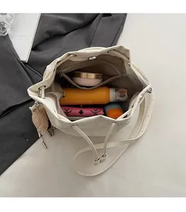 Interior view of white leather drawstring bucket bag showing spacious storage for essentials
