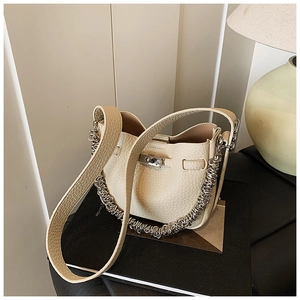 Dettaglio borsa a secchiello in pelle beige con chiusura a scatto in metallo argento