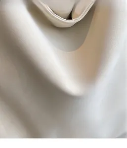 Detailed macro view of the soft lychee grain texture and minimalist brand label on the tote bag