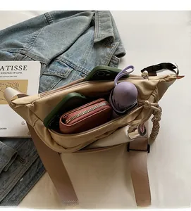 Detailed interior of beige nylon crossbody bag showing spacious main compartment storage