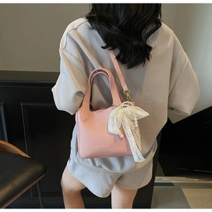 Pink lychee grain bucket bag with lace pearl bow charm and dual strap detail