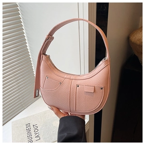 Close-up of pink crescent shoulder bag featuring lychee texture leather and silver rivets