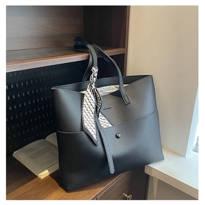 Detailed macro of black lychee texture tote bag with elegant geometric silk scarf