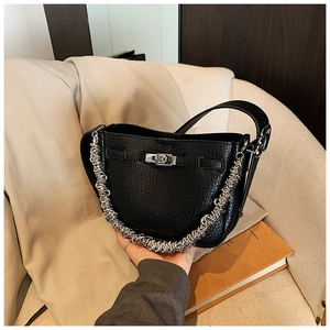 Dettaglio borsa in pelle martellata nera con catena d'argento e chiusura a girello