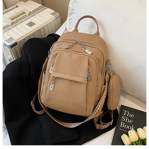 Detail of lychee textured leather backpack with metal zippers and jacquard shoulder strap