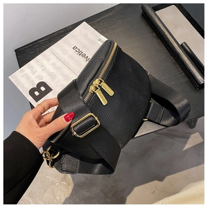 Detail of black lychee grain leather bag with dual gold zippers and wide nylon strap