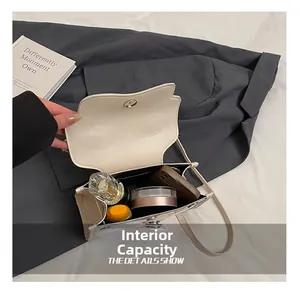 Detail view of the small cream leather crossbody bag interior showing storage capacity