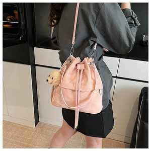 Pink drawstring bucket bag with textured leather and cute plush puppy charm accessory
