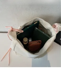 Spacious interior of off-white tote bag showing large capacity for tablets and water bottle