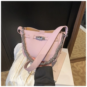 Dettaglio borsa in pelle rosa con chiusura a scatto argento e tracolla a catena spessa