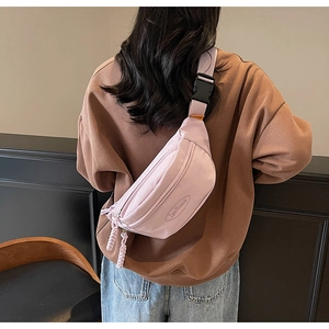 Close-up of pink canvas waist bag with adjustable strap and orange buckle detail