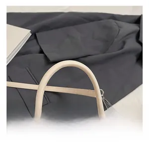 Detailed view of beige leather handbag handle with silver hardware and shoulder strap