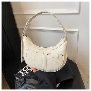 Detail of off-white crescent shoulder bag with lychee texture and rivet accents