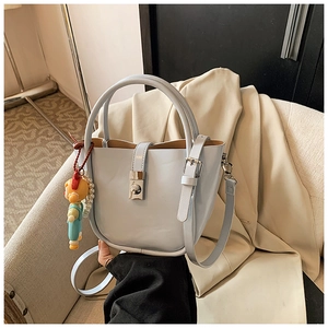 Detail view of light blue bucket bag with pearl chain and adjustable shoulder strap