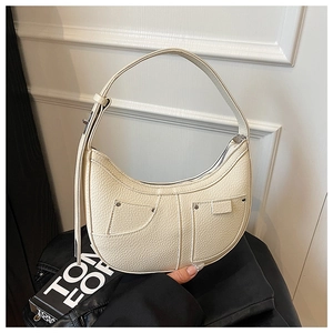 Close-up of off-white lychee leather hobo bag with silver studs and pocket details