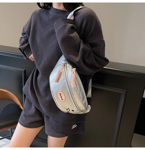 Marsupio argento con ricamo indossato su un completo casual nero in maglia a nido d'ape
