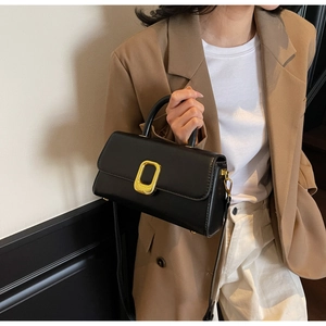 Détail d'un sac à main noir avec fermoir doré et texture en cuir synthétique raffiné