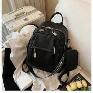 Detail of black lychee grain backpack with matching coin purse and arrow-patterned straps