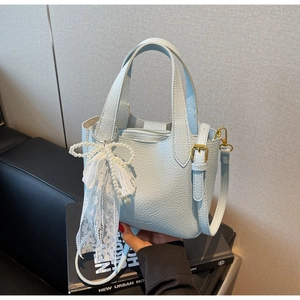 Detail of light blue lychee pattern leather bucket bag with lace pearl bow charm