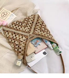 Close-up of the spacious interior of a woven straw tote bag with brown leather strap