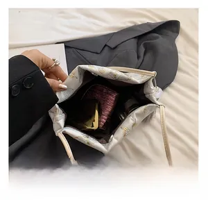 Close-up of embroidered butterfly satin bucket bag showing spacious interior capacity