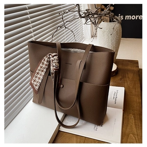 Detailed view of dark brown pebbled leather tote bag with a chic houndstooth silk scarf