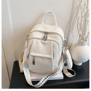 Detail view of off-white faux leather backpack with mini round pouch and geometric straps