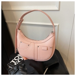 Detail of pink lychee leather shoulder bag with zipper and silver rivet accents