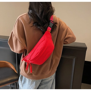 Rear view of a red nylon crossbody sports chest bag with adjustable strap and zipper